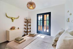 a bedroom with a large white bed and a window at Rocca Bella Escape by the Sea and Vineyards in Patrimonio +5 photos