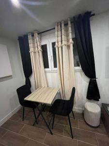 a table and chairs in a room with curtains at Palais des festivals Studio meublé in Cannes +9 photos