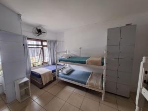 a bedroom with two bunk beds and a window at Hostel Feel Home in Blumenau