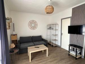 a living room with a couch and a table at STUDIO meublé à proximité gare-Wifi in Tonneins