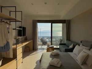 a living room with a bed and a large window at Marathon Coast-Seafront Luxury Apartments in Nea Makri