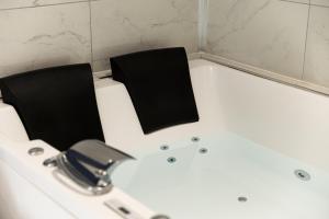 due sedie nere sedute in una vasca da bagno di LES BULLES DE MONA - Le Wilson - Spa a Villeurbanne
