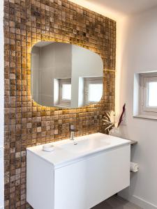 ブール・サン・モーリスにあるSki Cozy Bourg-Saint-Maurice Les Arcsの白い洗面台と鏡のあるバスルーム +11枚の写真