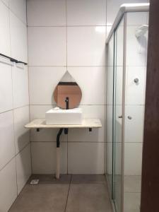 een badkamer met een wastafel en een douche bij Oxx in Congonhas