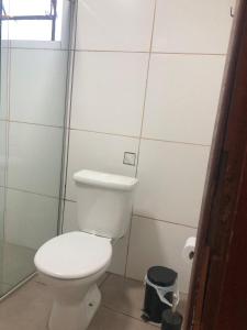 een badkamer met een wit toilet en een vuilnisbak bij Oxx in Congonhas