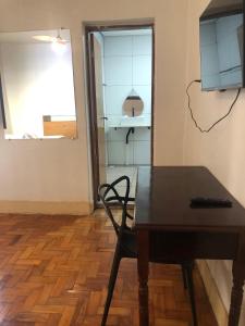 een tafel en een stoel in een kamer met een raam bij Oxx in Congonhas