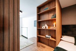 a bedroom with a wooden book shelf next to a bed at Matcha Studio in Bucharest