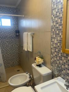 a bathroom with a toilet and a sink at Las Palmeras de Lavalle in San José