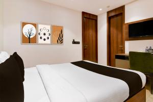 Un dormitorio con una cama, un escritorio y un televisor. en Super Townhouse Oak DLF Newtown Bus Terminal, en New Town