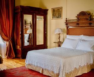 ミティリニにあるStiLiana Luxury Roomsのベッドルーム1室(ベッド1台、木製ヘッドボード、鏡付)