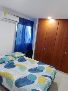a bedroom with a bed with a blue and yellow comforter at Los primos 2 in Santa Marta +9 photos