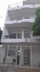 a white house with a gate in front of it at Los primos 2 in Santa Marta