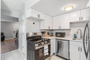 a kitchen with white cabinets and a stove top oven at All New! Convenient Location! Sleeps 6 in Denver