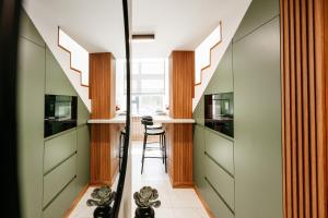 a hallway with stairs and a kitchen with stools at Matcha Studio in Bucharest