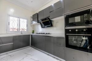 una cocina con electrodomésticos de acero inoxidable y una ventana en Serenity Apartments, en Old Yundum