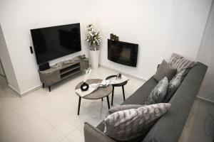 a living room with a couch and a tv at Villa Irene in Heraklio Town
