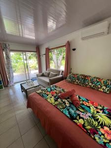 a bedroom with a large bed and a couch at Bungalove Kai Kabana in Tefarerii 