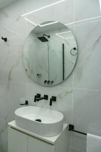 un bagno bianco con lavandino e specchio di Estudio Mare a Mar del Plata