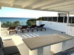 a patio with a table and chairs and the ocean at Fantasea Beachfront Villa in Makry Gialos