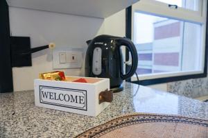 un forno a microonde appoggiato su un bancone con una scatola di benvenuto sopra di Estudio Mare a Mar del Plata Altre 9 foto