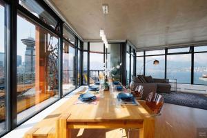 a long wooden table in a room with windows at Spacious 2BD in Vancouver Patio with Ocean View in Vancouver