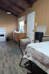 a bedroom with a bed and a kitchen with a sink at Las Casitas de Don Hugo in General Belgrano