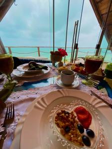 a table with a plate of food on a boat at DChalé in Japaratinga
