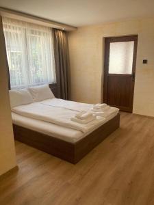 a large bed in a bedroom with a wooden floor at Guest house Dinaya-2 in Dobrinishte