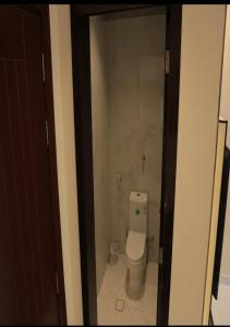 a bathroom with a toilet through a glass door at درب الحرمين in Jeddah