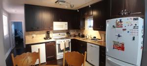 a kitchen with wooden cabinets and a white refrigerator at The Cozy Bungalow in North York Nest in Toronto