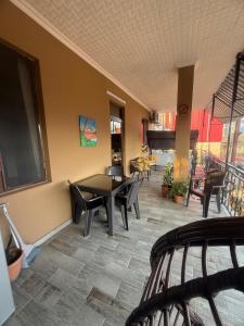 a room with a table and chairs and a piano at nino hotel in Kobuleti