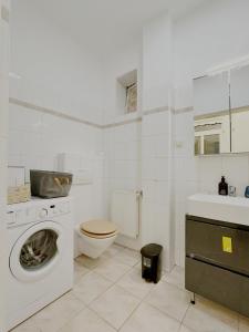 a white bathroom with a washing machine and a toilet at Apartment near Meidling in Vienna