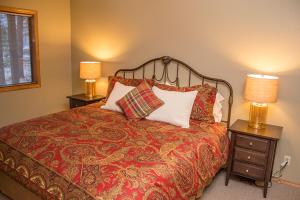 a bedroom with a bed with two night stands and two lamps at Sunriver Vacation House in Sunriver