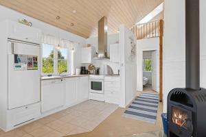 a kitchen with white cabinets and a stove at Peaceful Cottage In Scenic Surroundings in Højsand