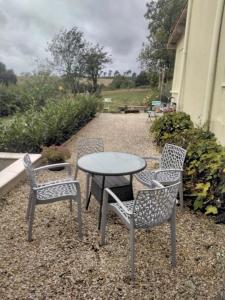 a table and two chairs and a table with a table and chairs at Charming pied-à-terre in Vieux-Ruffec