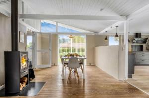 a kitchen and dining room with a table and a fireplace at Family-Friendly Activity House By The Sea in Frederikshavn