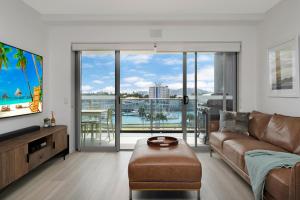 a living room with a couch and a view of the ocean at Harbourfront Views at Allure 2 Bedroom Apartment in Townsville