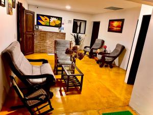 萨兰托Hostal Villa del Sol的带椅子、桌子和壁炉的客厅