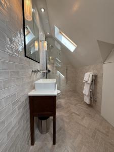 ein Badezimmer mit Waschbecken und Dusche in der Unterkunft The Brent Cross Penthouse in London