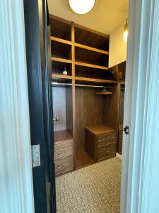 ein begehbarer Kleiderschrank mit Holzschränken und einer Schublade in der Unterkunft The Brent Cross Penthouse in London