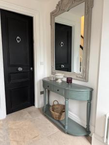 einen blauen Tisch in einem Zimmer mit Spiegel in der Unterkunft The Brent Cross Penthouse in London