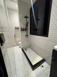 a bathroom with a shower with a toilet and a television at Le Chacal in Foumban
