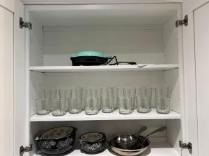 a cabinet filled with glasses and pots and pans at Evergreen Escapes 4 BR with Game Room, Firepit near Kalahari and Camelback in Long Pond