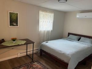 a bedroom with a bed and a table and a window at Evergreen Escapes 4 BR with Game Room, Firepit near Kalahari and Camelback in Long Pond +38 photos