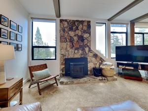 a living room with a stone fireplace and a television at 1849 Condos 542 condo in Mammoth Lakes