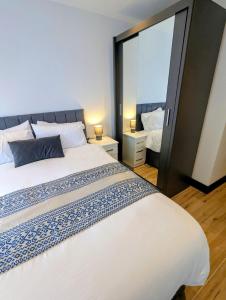 a bedroom with a large bed and a mirror at Elegant 2 bed flat with balcony in London in Finchley