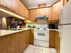 een keuken met houten kasten en een witte kookplaat oven bij Refuge Urbain Quebec - Loft Bonséjours in Québec