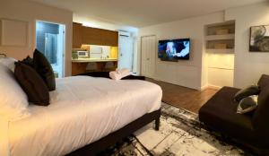 een slaapkamer met een groot wit bed en een bank bij Refuge Urbain Quebec - Loft Bonséjours in Québec