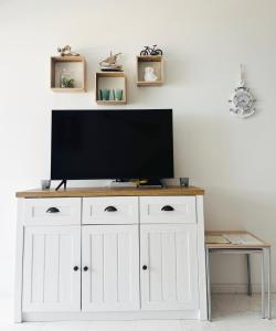 a tv on a white cabinet in a living room at Unique apartment with direct sea view along the beach in S'Abanell Central Park Blanes in Blanes