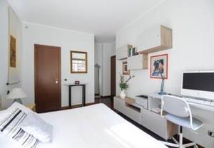a bedroom with a bed and a desk with a computer at "Suite Sempione Park" 2 bedrooms - 2 bathrooms in Milan